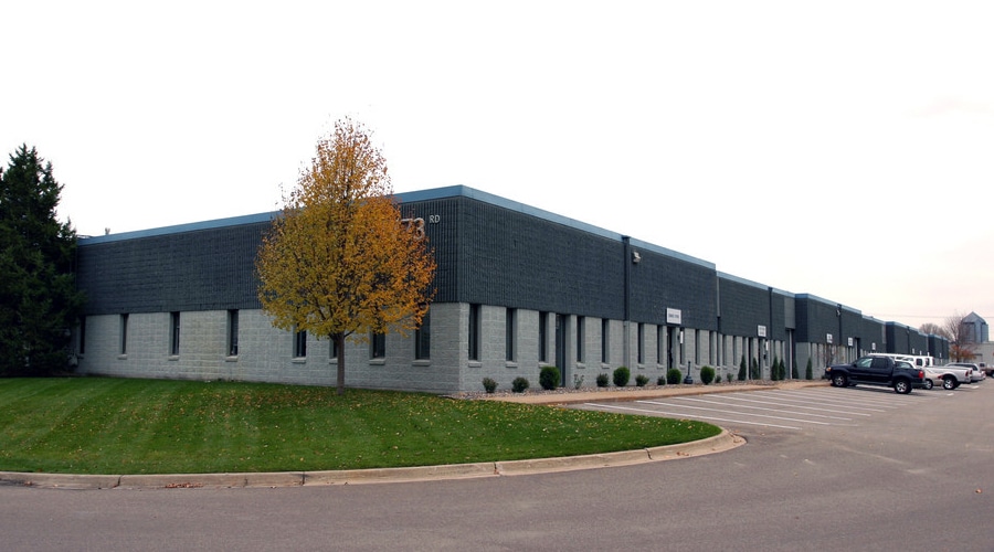 Image of Printastik's printshop in Edina, Minnesota with green lawn, gray building, and tree