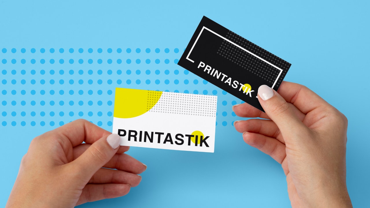A person holds a pair of differently designed business cards printed by Printastik in Edina, Minnesota.